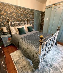 a bedroom with a bed and a wall with a pattern at The Crown Inn Dial Post in Horsham