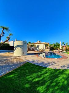 a yard with a swimming pool and a green lawn at New holiday house "Casa miAlina" with private pool, 300m to beach in Cambrils