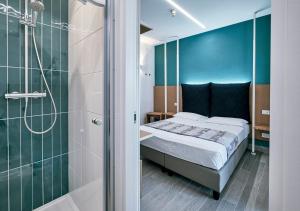 una camera con letto e doccia in vetro di Hotel & Restaurant Storyville a Cinquale