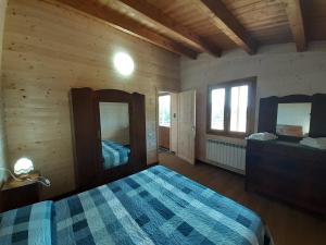 a bedroom with a bed and a dresser and two mirrors at Agriturismo D'Apostolo in Amatrice