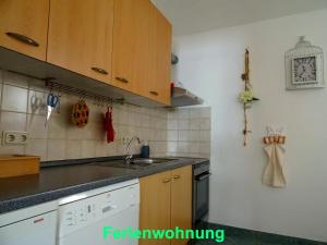 una cocina con armarios de madera y fregadero en Ferienwohnung Sobrigau, en Sobrigau