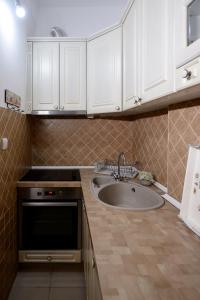 a kitchen with a sink and white cabinets at Apartman Centar Lux Valjevo in Valjevo
