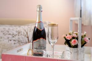 a bottle of wine sitting on a table with a glass at Apartman Centar Lux Valjevo in Valjevo