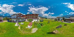 a large building on a green field with mountains at Hotel-Restaurant Sonnhof in Radfeld