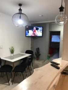 salon ze stołem i telewizorem na ścianie w obiekcie Mieszkanie u Tomka INPIW02 w mieście Piwniczna
