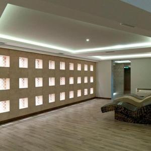 Habitación con pared con ventanas y sofá. en Apartman D16 Milmari Kopaonik, en Kopaonik