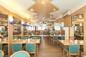 a restaurant with wooden tables and blue chairs at Hotel Primus Frankfurt Sachsenhausen in Frankfurt/Main