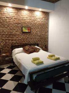 a bed in a room with a brick wall at Departamento Amoblado con Cochera in Villa María