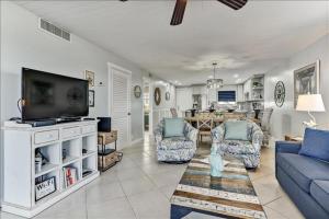 a living room with a blue couch and a tv at Amelia By The Sea in Fernandina Beach
