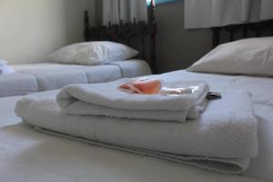 a pile of towels sitting on top of a bed at Hotel Nossa Senhora Aparecida in Ouro Preto