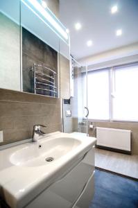 y baño con lavabo blanco y espejo. en Amazing apartment in the center of Kiev en Kiev