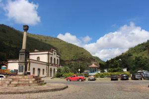 un edificio con un monumento frente a una montaña en Hotel Nossa Senhora Aparecida, en Ouro Preto
