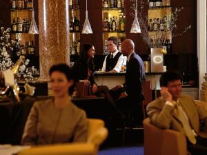een groep mensen die aan een bar zitten bij Hotel Ambassador in Wenen