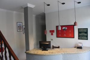 Una habitación con un mostrador con una computadora encima. en Hotel Nossa Senhora Aparecida, en Ouro Preto