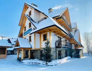 ein Haus mit Schnee auf dem Dach in der Unterkunft Willa Dolina Harenda in Zakopane