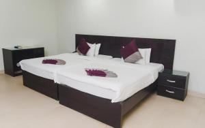 a large bed with red pillows on top of it at Korkdam Hotel in Achimota