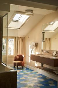 a bathroom with a large sink and a mirror at H&ocirc;tel du Sentier in Paris