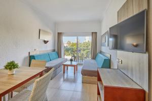 a living room with a couch and a tv at Apartamentos Ben-Hur in Playa de Palma