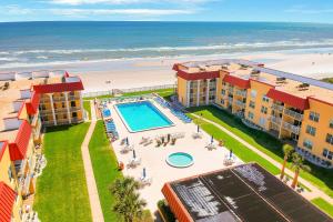 an aerial view of a resort with a swimming pool and the beach at Point East in New Smyrna Beach