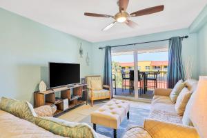 a living room with a couch and a flat screen tv at Point East in New Smyrna Beach