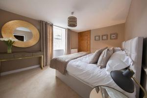 a bedroom with a large bed and a mirror at No.25 Steep Hill - Award Winning Street, Cathedral Quarter, Lincoln - Free Parking in Lincoln