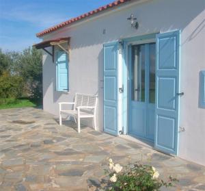 a house with a blue door and a white chair at Kefalas nr Almyrida sea view cottage in Chania Town