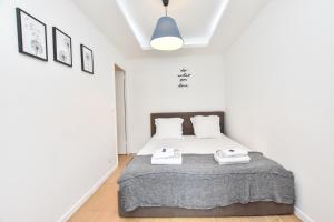 a white bedroom with a bed with two towels on it at CMG Louvre Rivoli - Châtelet in Paris