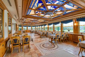 a restaurant with tables and chairs and a chandelier at Hotel Haus Tiefenbach in Bullange