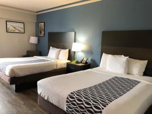 A bed or beds in a room at La Quinta by Wyndham PCB Coastal Palms