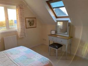 Lovely 1-Bed House in Stirling في ستيرلينغ: غرفة نوم مع سرير وخزانة مع مرآة