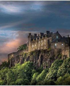 een kasteel aan de zijkant van een berg bij Lovely 1-Bed House in Stirling in Stirling