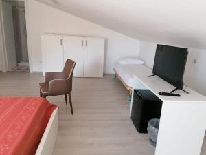 a room with a bed and a desk with a television at Arco Fiorito in Cittadella del Capo