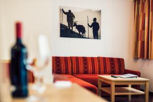 a living room with a red couch and a picture on the wall at Die Reblaus in Ladis