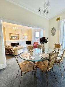 a living room with a glass table and chairs at Large Luxury Apartment Blackpool in Blackpool