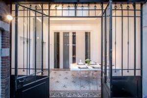 een glazen deur die leidt naar een kamer met een tafel bij Maison Noppius in Luik