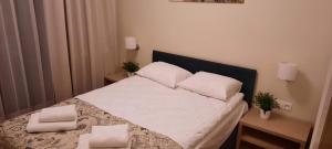 a bedroom with a bed with white sheets and pillows at Apartament DeLux Marina in Kąty Rybackie