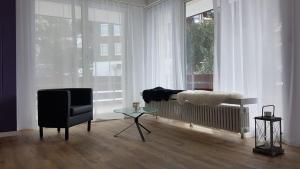 sala de estar con sofá, silla y ventana en Dorfklatsch Ferienwohnung, en Emmetten