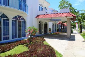 a building with a red awning next to a sidewalk at Hotel Mexico Lindo in Santa Cruz Huatulco