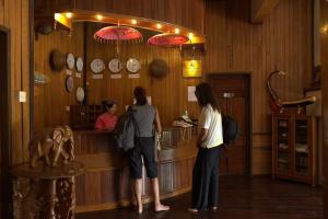 two people standing at a counter in a store at Pine Hill Resort in Kalaw