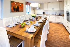 a large wooden table in a kitchen with white cabinets at Schwedenhus in Wangerooge