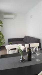 a living room with a couch and a table with wine glasses at Apartments ARTEMIS in Baška
