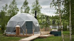 a dome tent with a wooden deck in a field at Glamping DiDille in Drusti