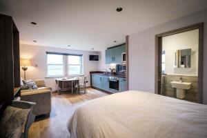 a bedroom with a bed and a kitchen with a sink at Stones Throw in Grayrigg