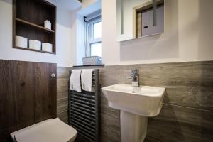 a bathroom with a white sink and a toilet at Stones Throw in Grayrigg