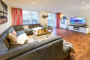 ein Wohnzimmer mit einem Sofa und einem TV in der Unterkunft Schwedenhus in Wangerooge
