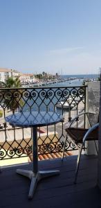 uma mesa e cadeiras numa varanda com vista para a água em Hotel-Restaurant Du Port em Mèze