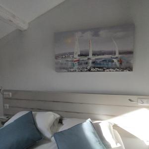 een schilderij boven een bed in een slaapkamer bij Hotel-Restaurant Du Port in Mèze