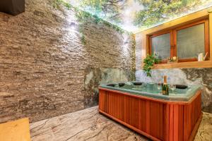 uma casa de banho com uma banheira de madeira numa parede de tijolos em U Repy em Bańska