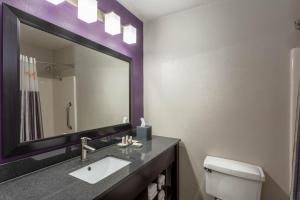 
a bathroom with a sink, mirror, and toilet at La Quinta by Wyndham Orlando Universal area in Orlando
