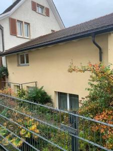 uma casa com uma cerca em frente a um jardim em Charming 2-Bed Apartment in Arlesheim 15 min Basel em Arlesheim